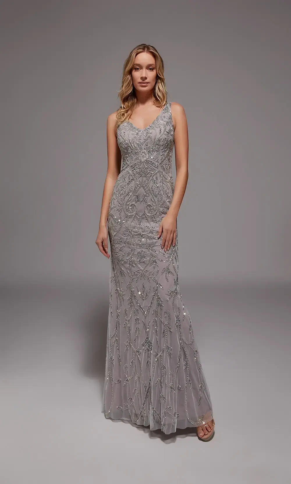 model is wearing a sleeveless beaded grey evening gown