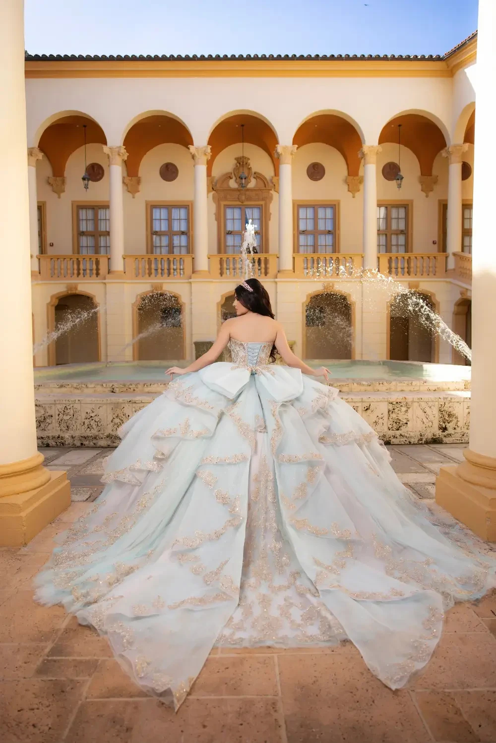 model is wearing a light pink quinceanera gown