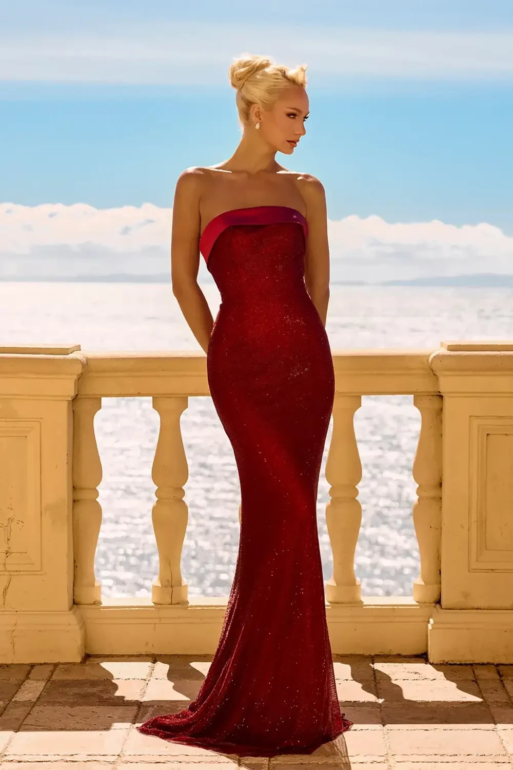model is wearing a strapless deep red evening gown